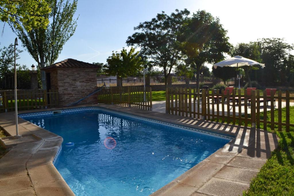 a swimming pool in a yard with a fence at 5 bedrooms villa with private pool jacuzzi and enclosed garden at Fernan Caballero in Fernancaballero