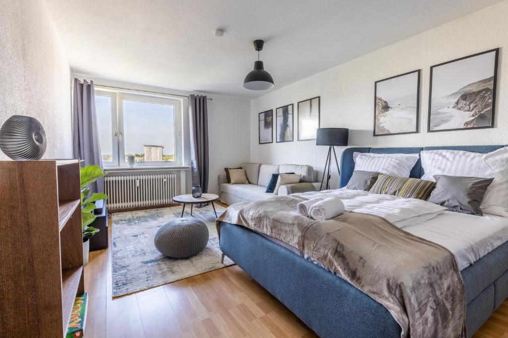 a bedroom with a blue bed and a living room at Stilvolles Apartment inmitten der Altstadt in Duisburg