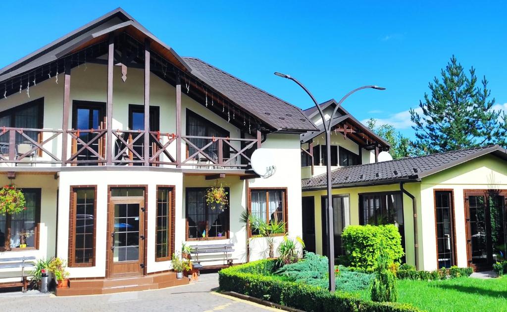 a house with a balcony on top of it at Villa Diola in Kosiv