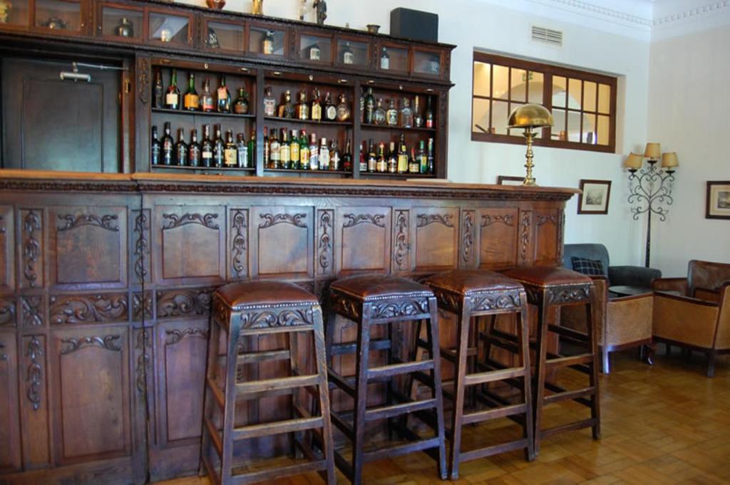um bar de madeira com bancos num quarto em Hotel Urgeirica em Nelas