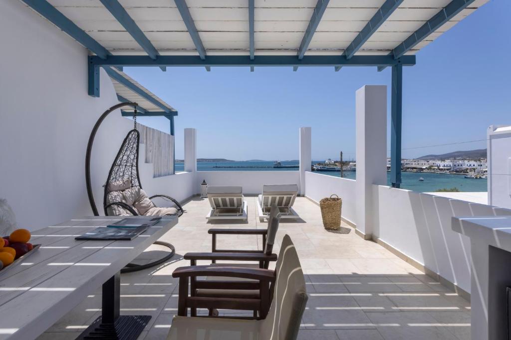 a balcony with a table and chairs and a view of the ocean at Kouros Village in Antiparos