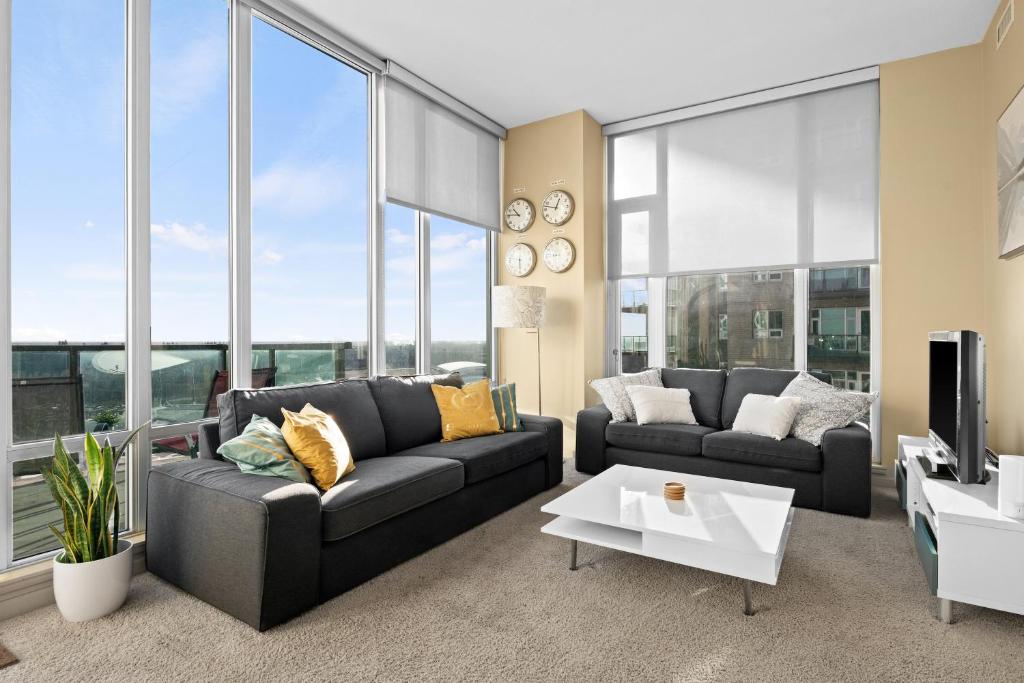 uma sala de estar com dois sofás e uma televisão em Gorgeous Downtown Calgary Condos by GLOBALSTAY Free Parking em Calgary