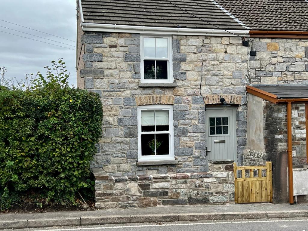 a stone house with two windows and a door at Gorgeous 2-Bed Cottage in Penderyn Brecon Beacons in Aberdare