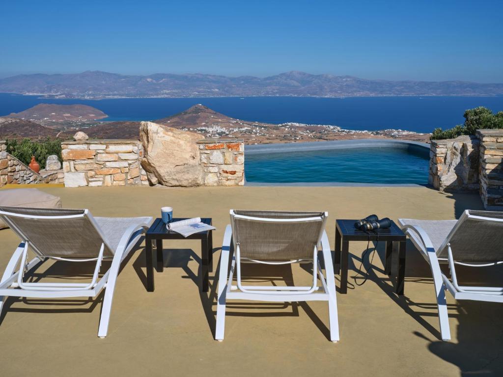 a group of chairs and tables with a view of the water at VILLA STELLA, LEFKES PAROS in Lefkes