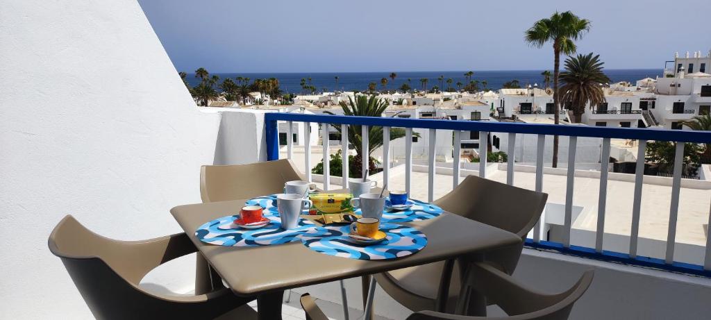- Balcón con mesa y sillas y vistas a la playa en Apartamento Oasis Azul, vista oceano. en Puerto del Carmen
