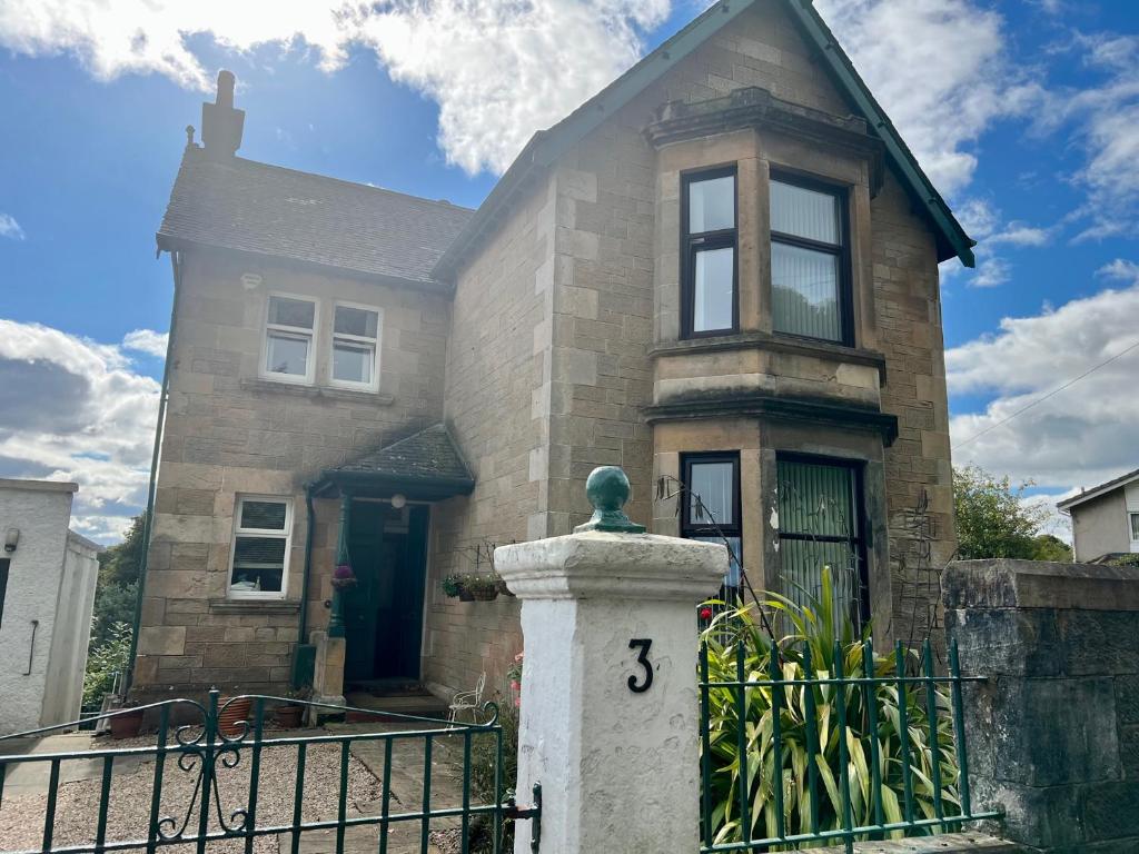 una casa de ladrillo con una puerta y una valla en Glasgow Emo, en Glasgow