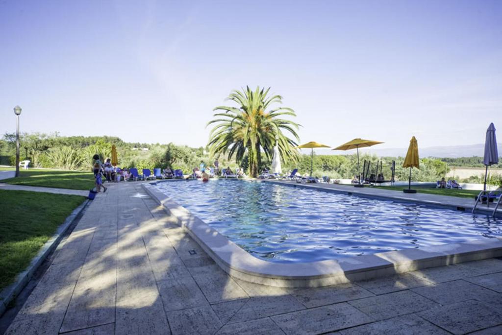 uma grande piscina de gua com pessoas sentadas  sua volta em Hotel Urgeirica em Nelas