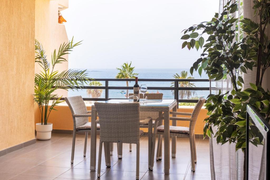 jadalnia ze stołem i krzesłami na balkonie w obiekcie Frontline Penthouse with heated pool and parking w mieście Los Cristianos