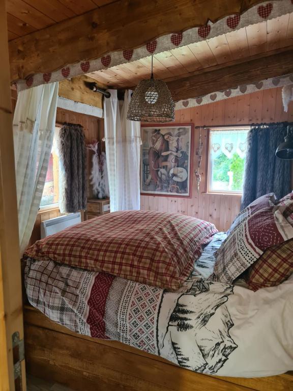 a bedroom with a bed in a log cabin at Chez steph et frank in Morez