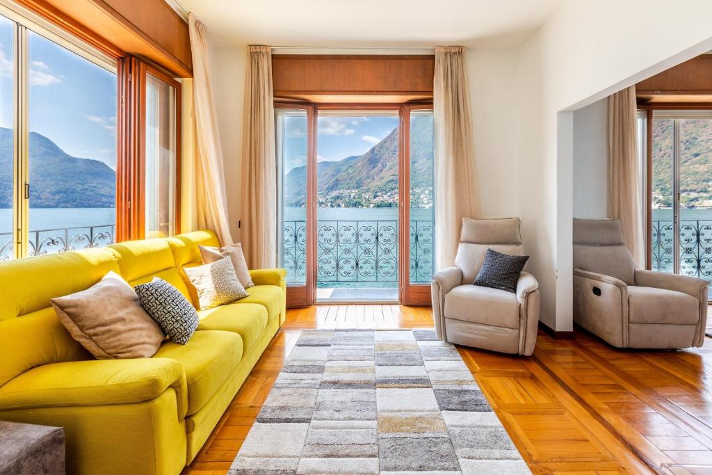 - un salon avec un canapé jaune et des fenêtres dans l'établissement Villa La Luna, à Pognana Lario