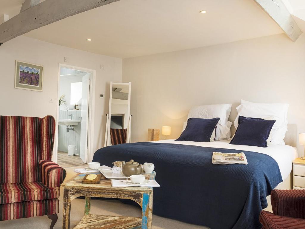 een slaapkamer met een bed, een tafel en een stoel bij Wild Garlic Rooms in Nailsworth