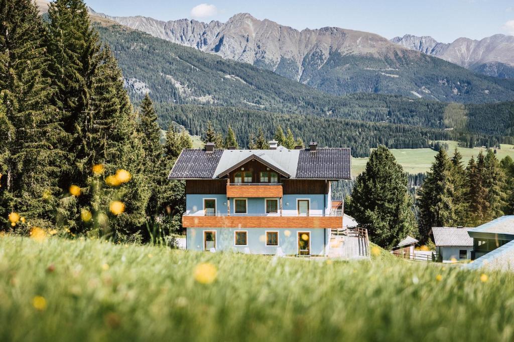 una casa en una colina con montañas en el fondo en Appartementhaus Samson Fanningberg, en Weisspriach