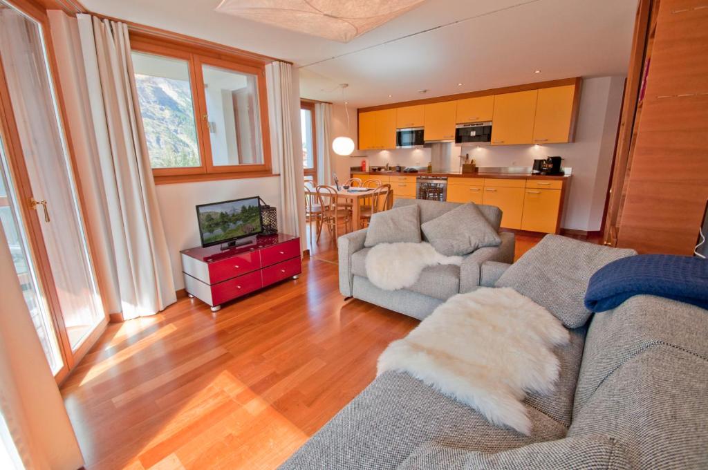 ein Wohnzimmer mit einem Sofa und einer Küche in der Unterkunft Casa D'Amore, Apartment Lyskamm in Zermatt