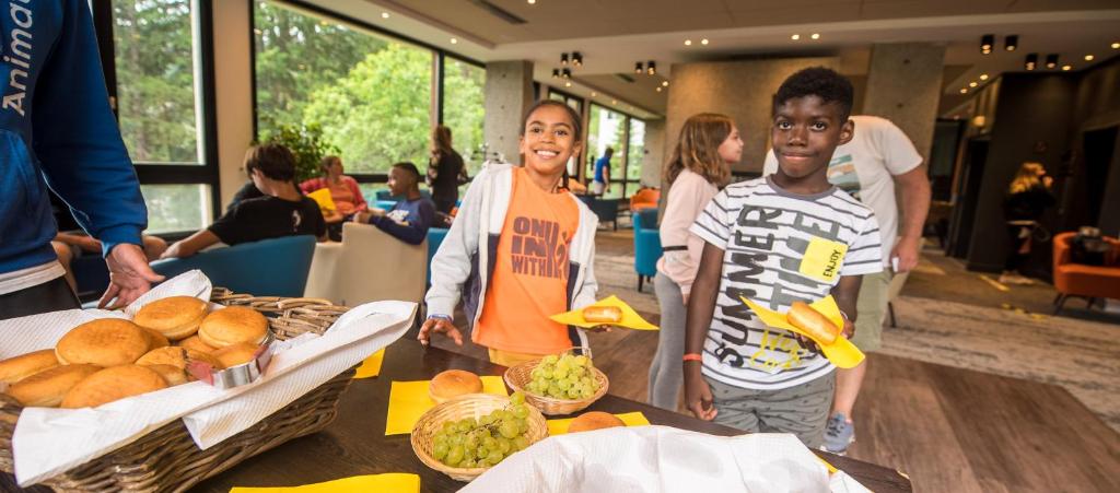 two children standing in front of a table of food at Hôtel Club mmv Le Flaine *** in Flaine