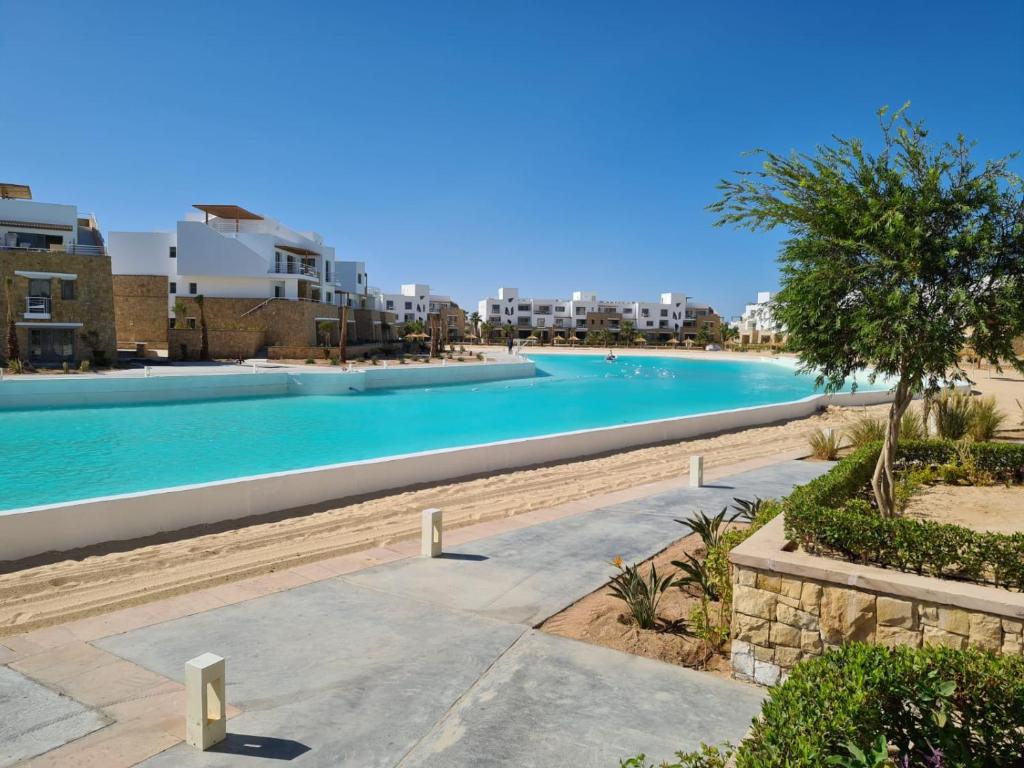a large swimming pool with blue water and buildings at EL Gouna Swan Lake Apartment in Hurghada