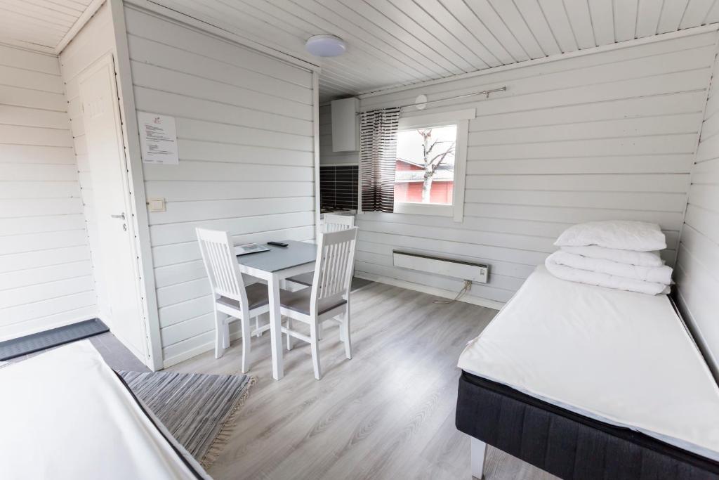 Cette chambre comprend un lit, une table et des chaises. dans l'établissement Crow Creek Cabins, à Inari