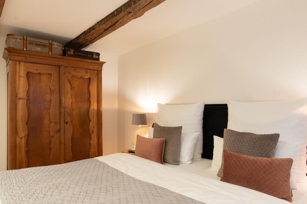 a bedroom with a bed with white sheets and pillows at Kulturdenkmal der Gänsbühl auf der Stadtmauer in Gengenbach