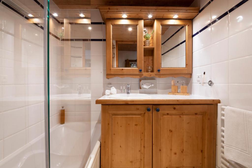 a bathroom with a sink and a tub and a shower at Résidence Pierre & Vacances Premium Les Fermes De Méribel in Méribel
