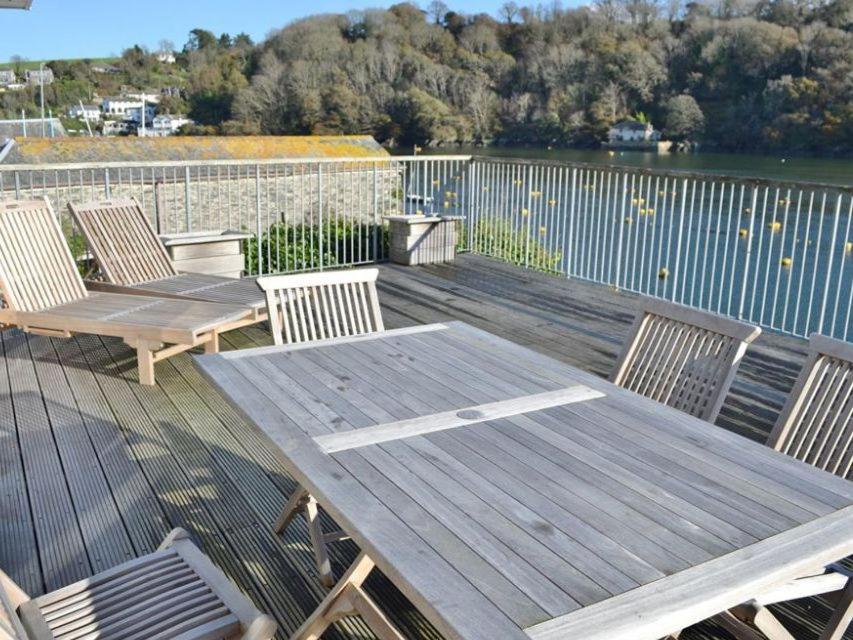 a wooden deck with two chairs and a wooden table at Lower Deck in Fowey