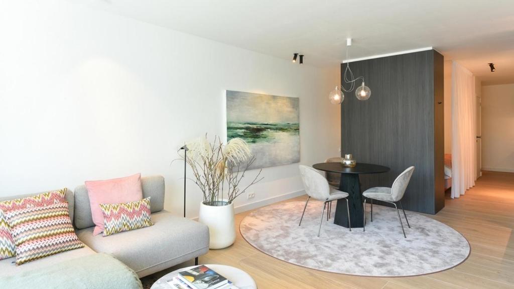 - un salon avec un canapé et une table dans l'établissement Orfeo Knokke, à Knokke-Heist