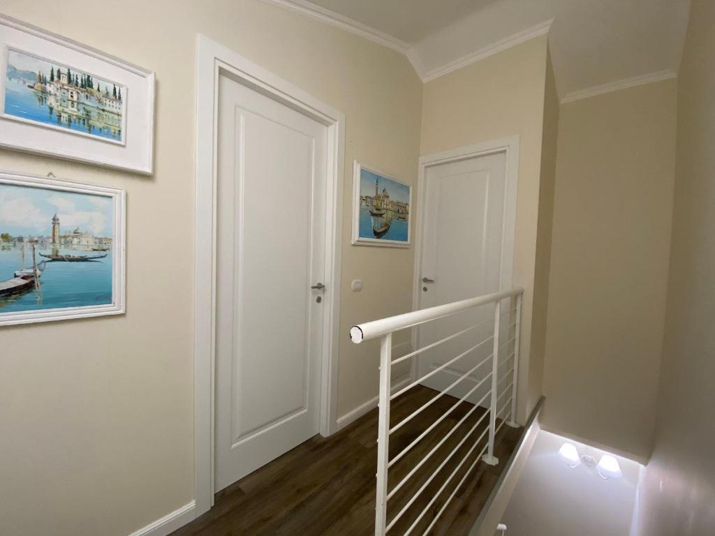 a hallway with a white door and a staircase at B&B L'Ulivo Fiumicino in Fiumicino