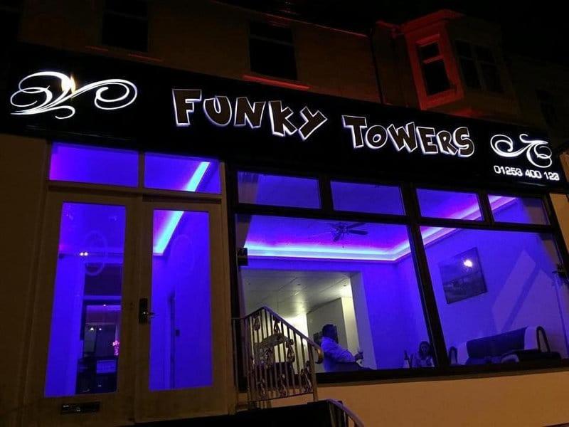 ブラックプールにあるFunky Towersの窓に紫色のライトが入る店舗