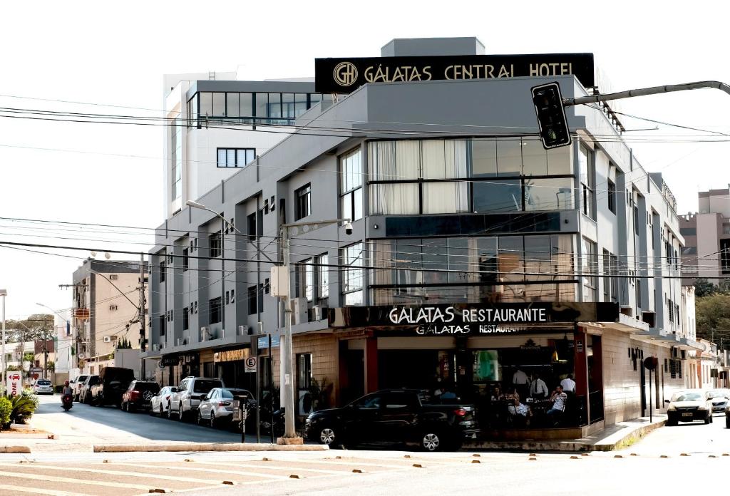 ein Gebäude in einer Stadtstraße mit einer Ampel in der Unterkunft Galatas Central Hotel in Patos de Minas