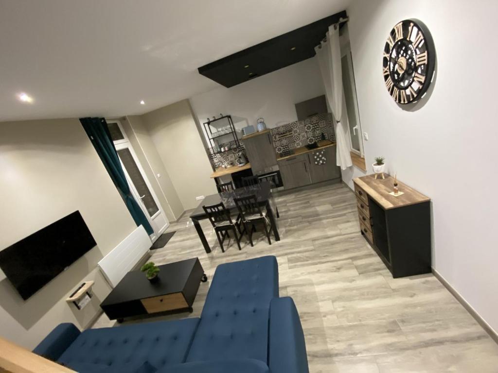 un soggiorno con un divano blu e un tavolo di Côté Village By Mel & Jérôme a Roclincourt