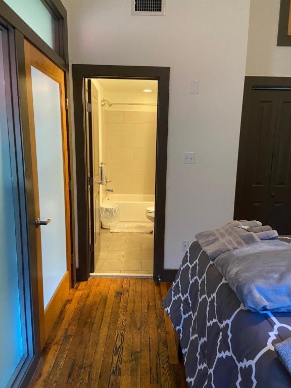 a bedroom with a bed and a bathroom with a tub at Charming 2 bedroom apartment near VCU in Richmond