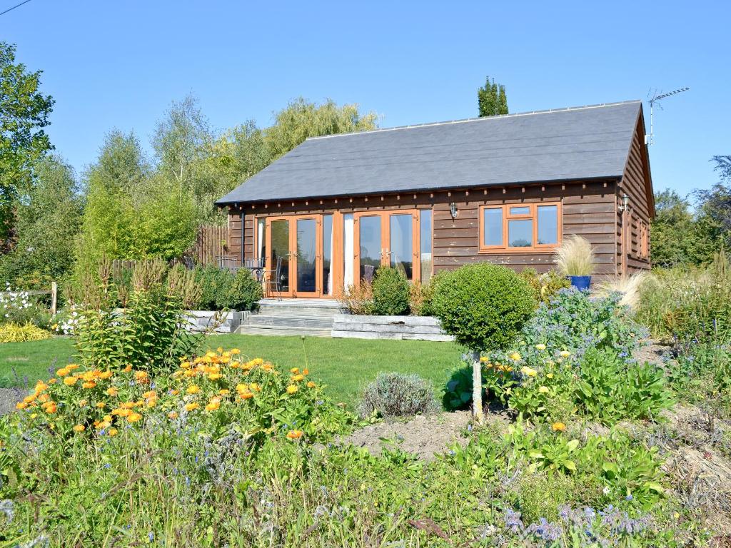 a wooden house with a garden in front of it at Lavender Lea in Landford