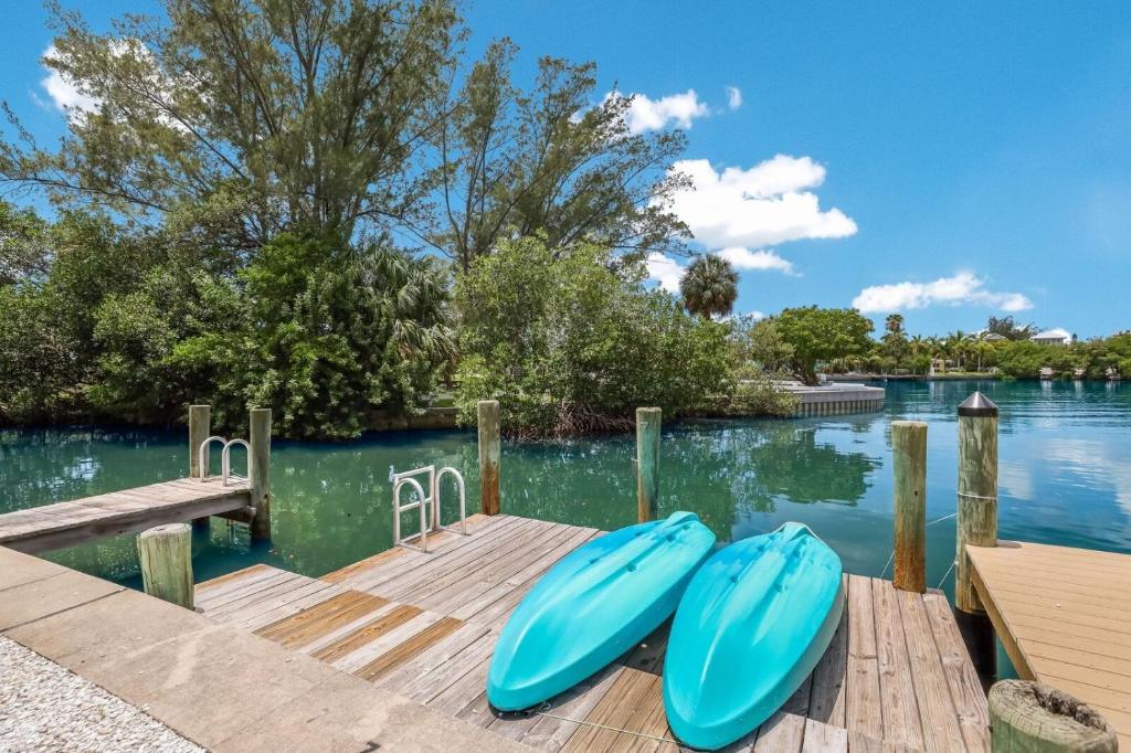 a dock with two blue boats on the water at Coconut Bayou home in Anna Maria