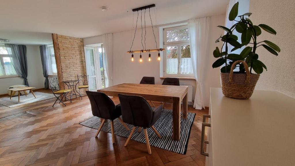 a dining room with a table and chairs and a plant at Gasthof - Auszeit im Bad Diezlings - Adults only in Hörbranz