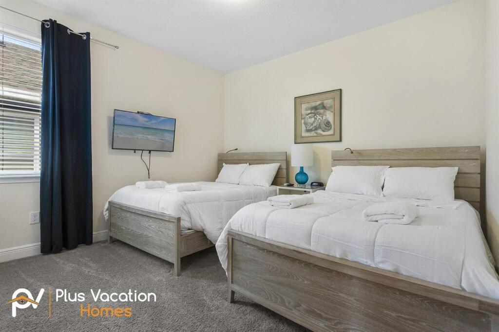 a bedroom with two beds and a tv on the wall at 331-Luxury Villa wPOOL & SPA By Disney in Orlando