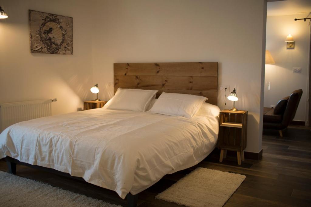 sypialnia z dużym białym łóżkiem i dwiema lampami w obiekcie Coin de Charme au Pays Basque w mieście Hasparren