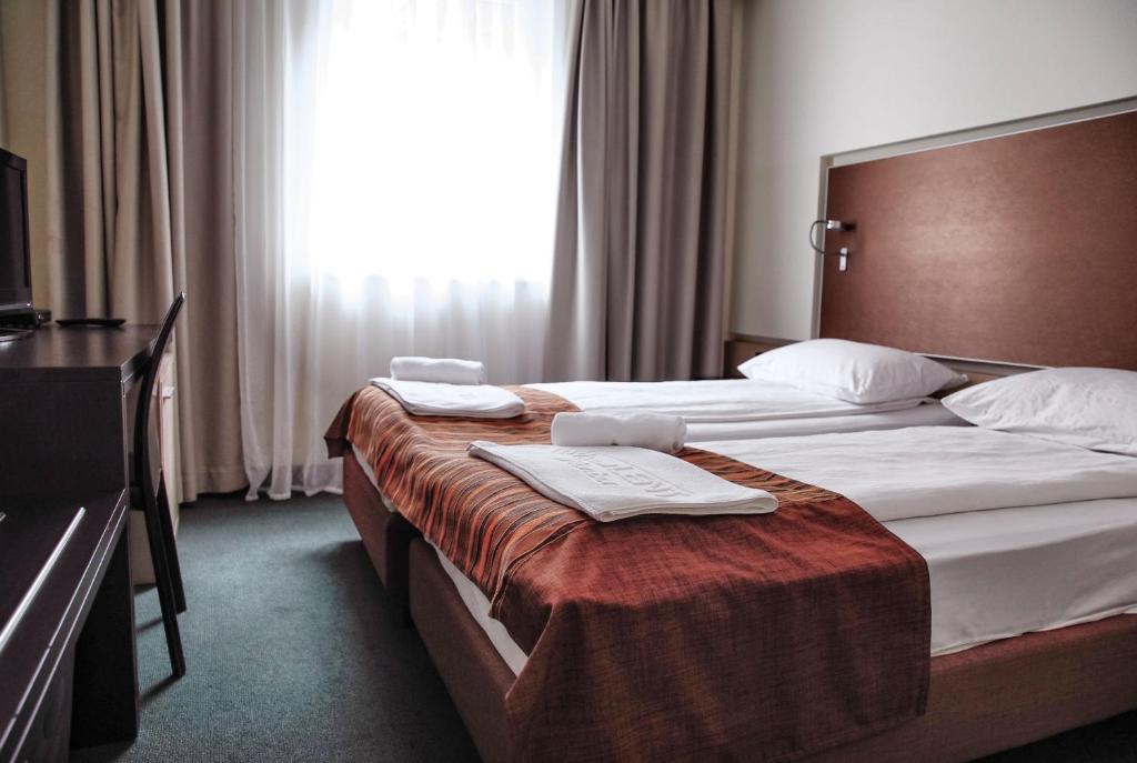 um quarto de hotel com duas camas e uma janela em Hotel Lent superior em Maribor