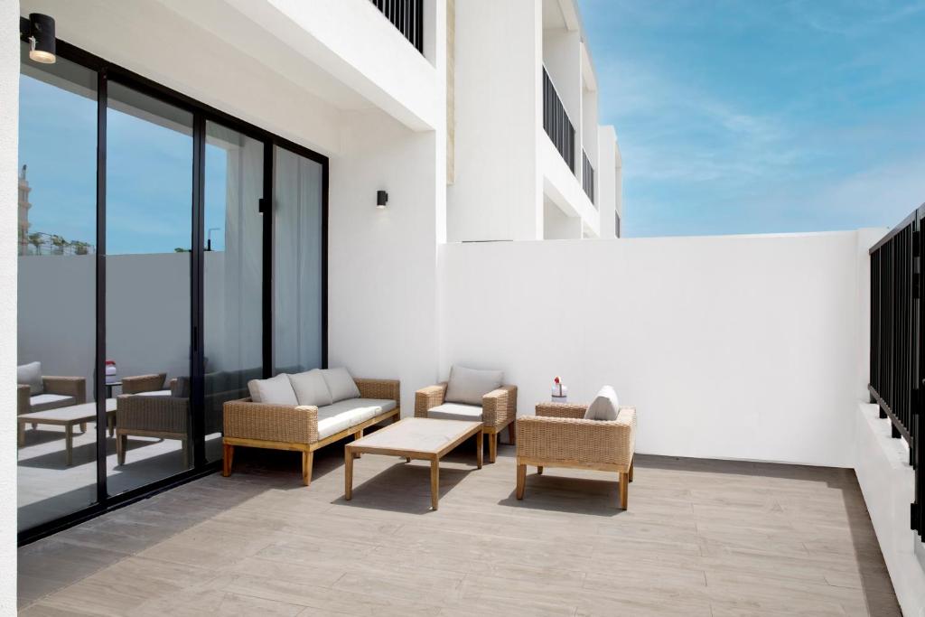 un patio avec des chaises et des tables dans un bâtiment dans l'établissement Oasis Homes by Olala Homes, à Ras al Khaimah