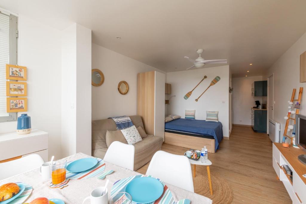 una pequeña sala de estar con cama y mesa. en La Paradis bleu - Parking privé - Literie confortable - Vue port - Plage à 5 min, en La Grande-Motte