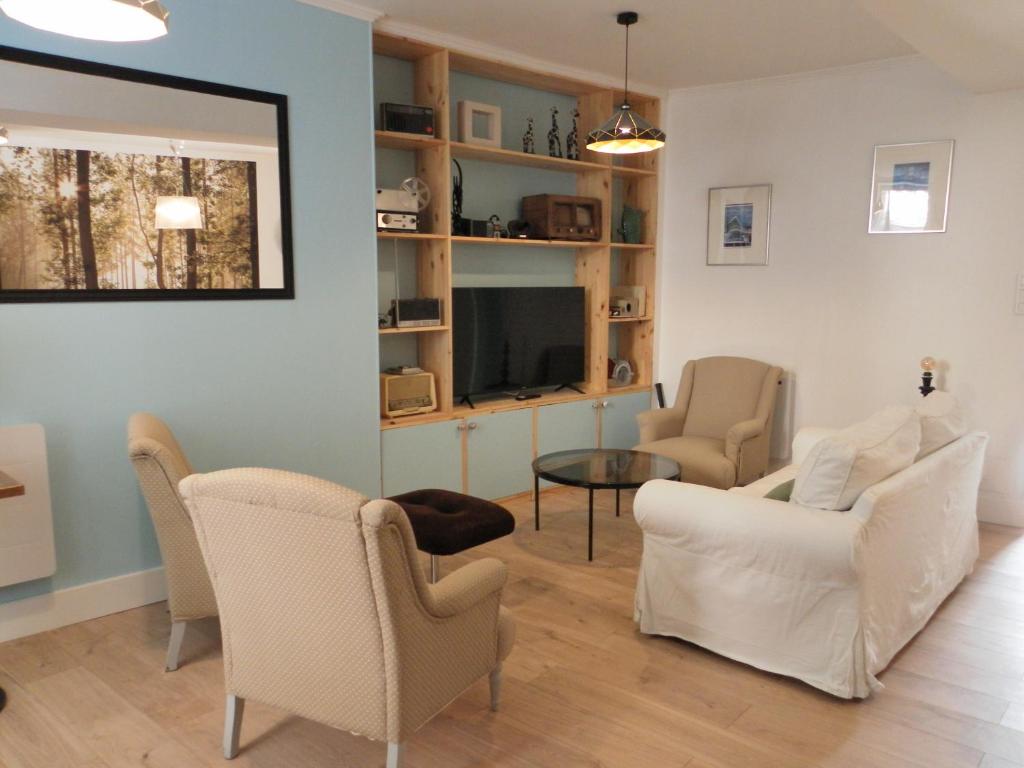un soggiorno con 2 sedie e una TV di Au 66 Maison centre ville-Parking gratuit et WIFI a Nogent-le-Rotrou