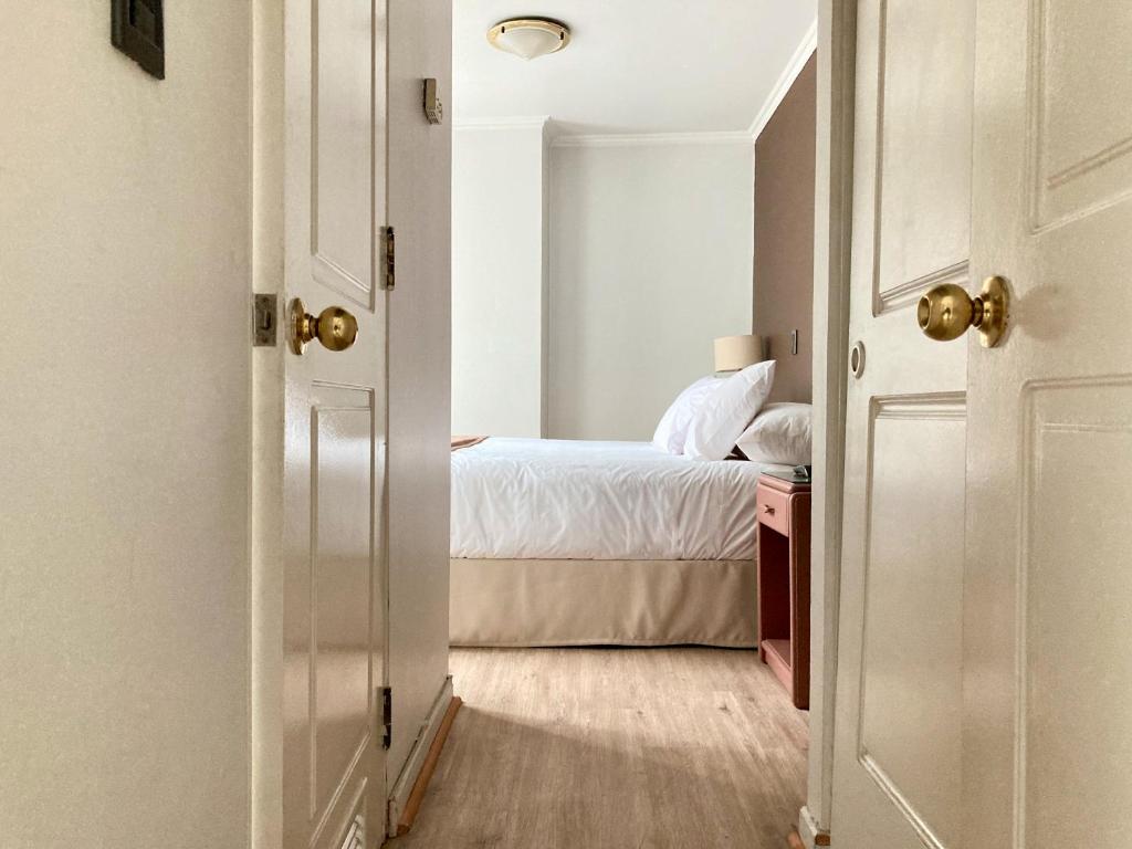 uma porta que leva a um quarto com uma cama em Apart Hotel Elite Las Condes em Santiago