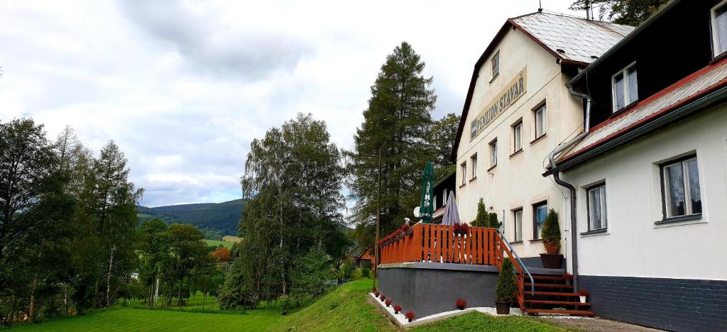 a building with an orange balcony on the side of it at Penzion Stavař in Vrbno pod Pradědem