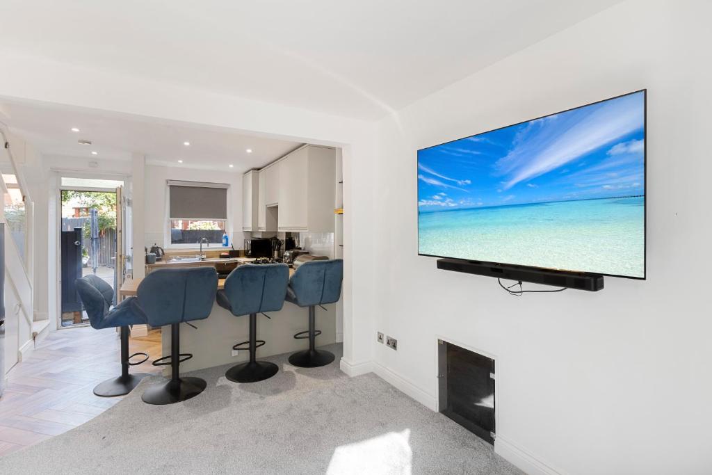 een woonkamer met een flatscreen-tv aan de muur bij River Exe Cottage waterfront in Exeter