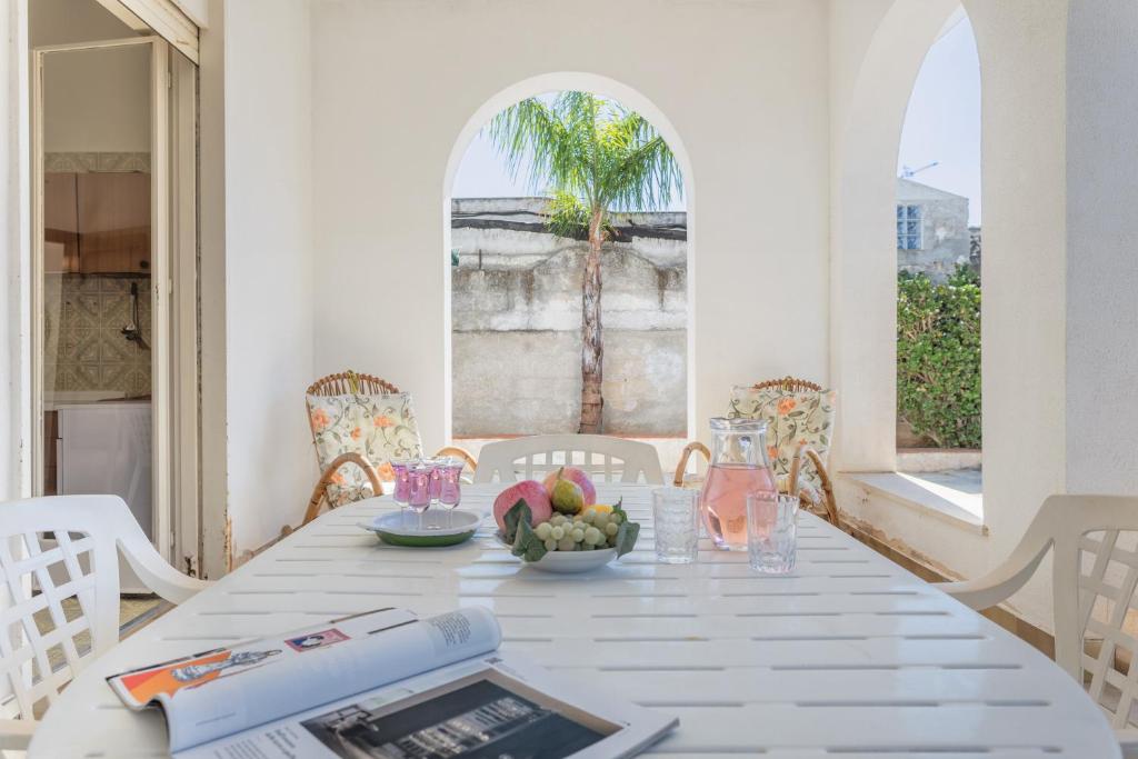 einen weißen Tisch mit einer Schale Obst drauf. in der Unterkunft Villa Carlotta Vicino Al Mare in Carini