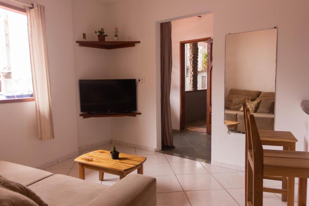 a living room with a couch and a tv and a table at Casa do Pepe in Cayru