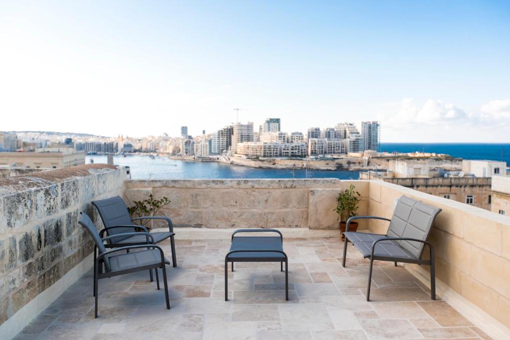 a balcony with chairs and a view of the city at Valletta Collection - 101 Republic in Valletta
