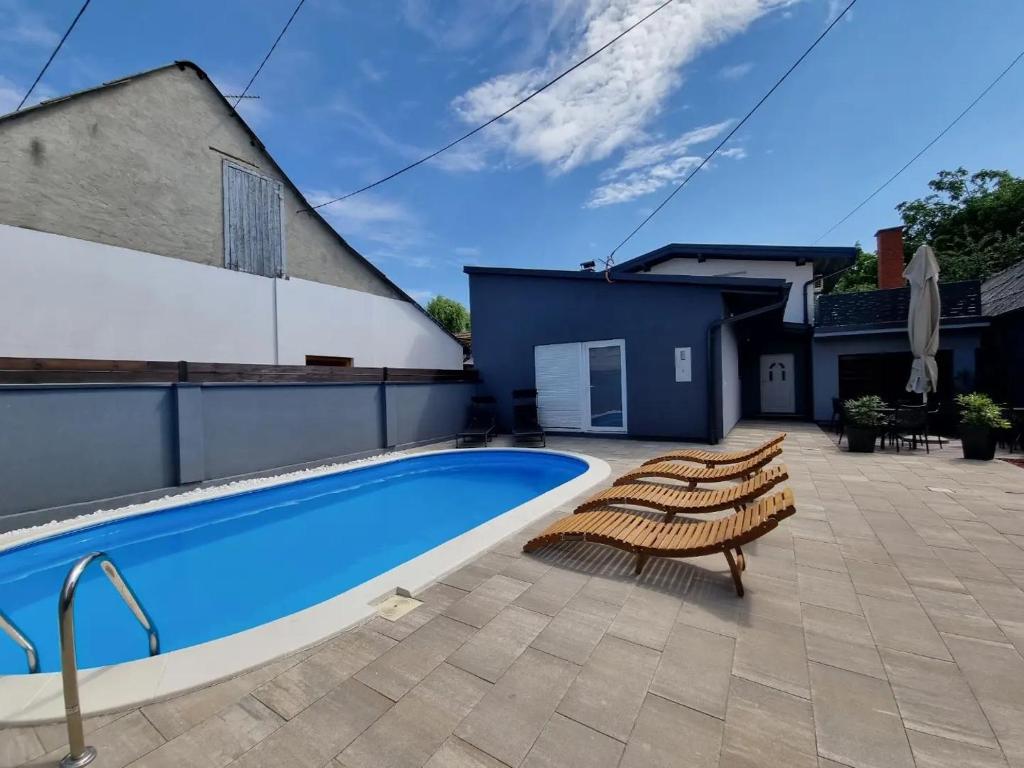 a patio with a swimming pool and chairs and a building at Kuća za odmor Maja in Đakovo