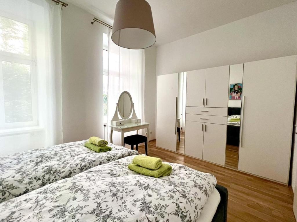 a bedroom with two beds with green towels on them at City-Apartment in Wieden in Vienna