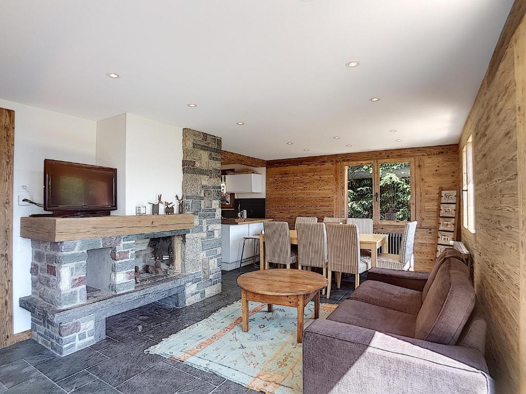 a living room with a couch and a fireplace at Fouquet Apartments in Verbier