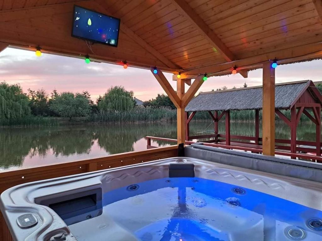 - un bain à remous sur une terrasse couverte avec une télévision dans l'établissement Gólya-Tó Vendégház, à Vajdácska