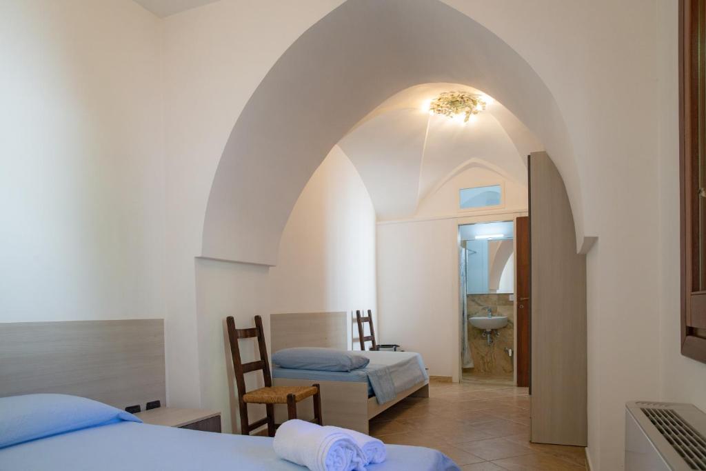1 Schlafzimmer mit 2 Betten und einem Torbogen in der Unterkunft B&B Casa Maddalena in Campi Salentina