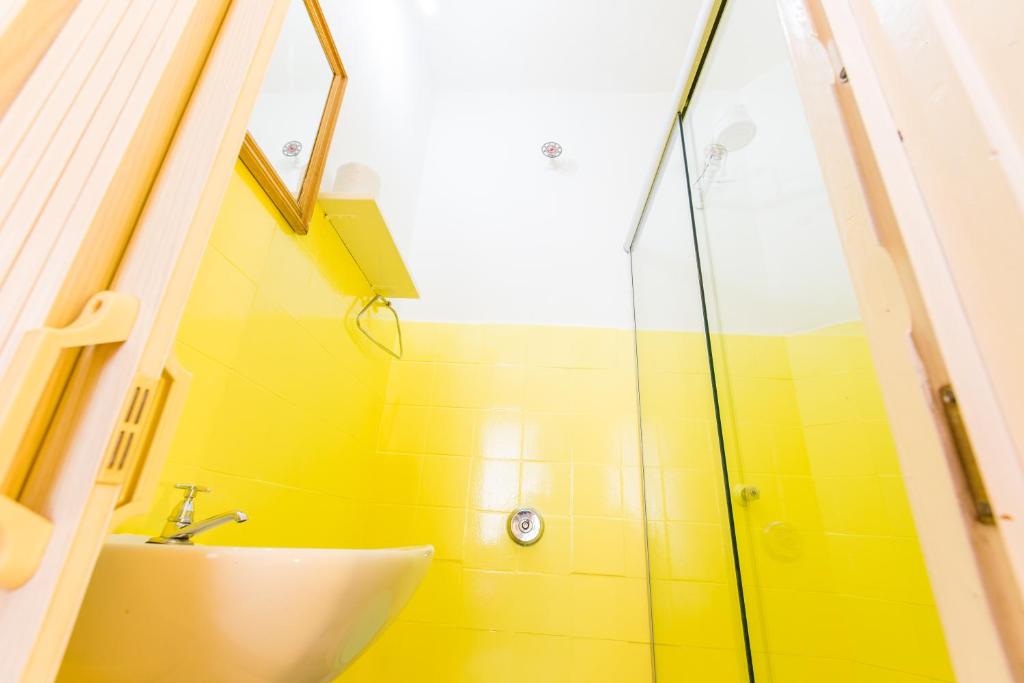 クリチバにあるHotel Blumenau Centroのバスルーム(洗面台、ガラス張りのシャワー付)